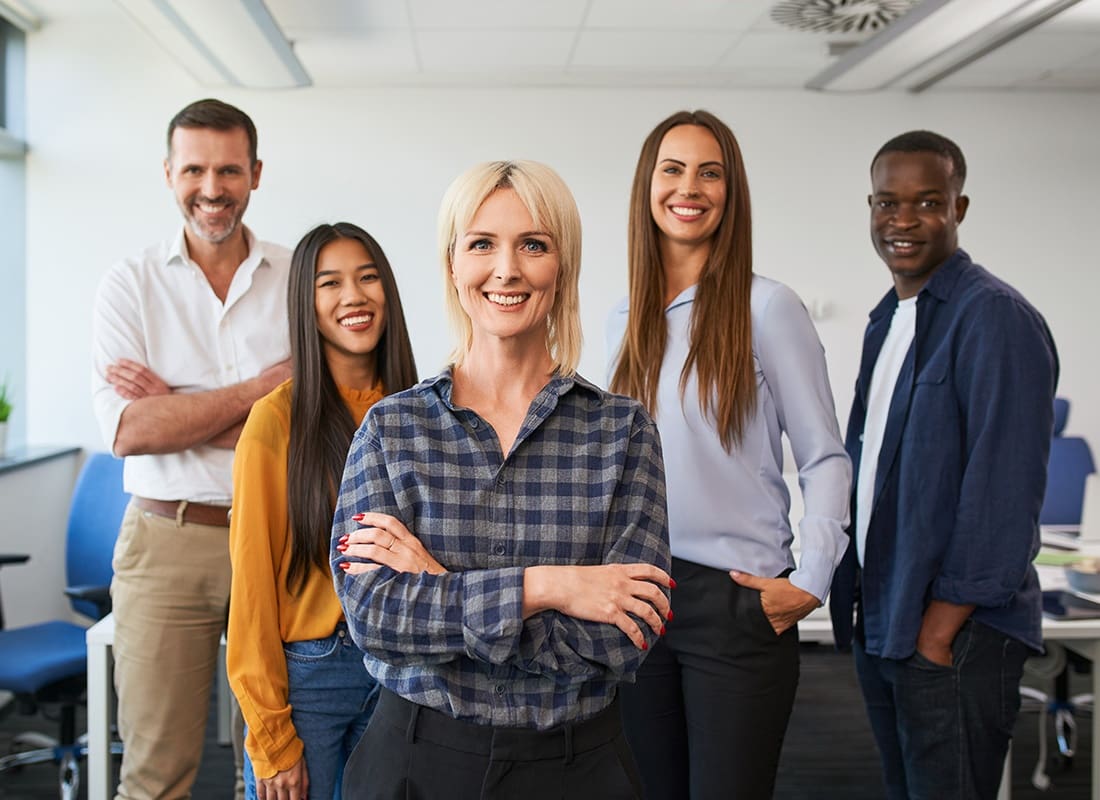 Employee Benefits - Smiling Group of Diverse Employees Standing in a Small Office